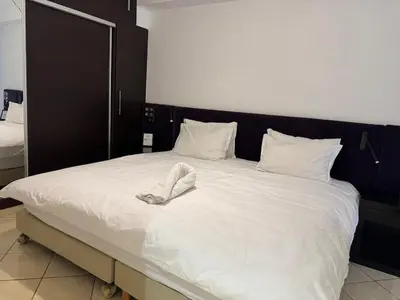 a large white bed with a pair of shoes on it at Dana in Beni Mellal