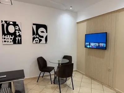 a waiting room with a table and a tv on a wall at Dana in Beni Mellal