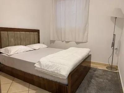 a bedroom with a large bed with white sheets and a window at Dana in Beni Mellal