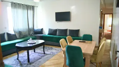 a living room with a green couch and a table at City Center Stay - Résidence Omar 1 by ZenStay in Fès