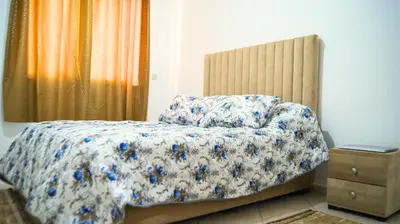 a bedroom with a bed with a floral comforter at City Center Stay - Résidence Omar 1 by ZenStay in Fès