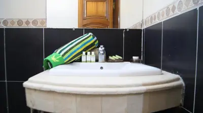 a bathroom with a white sink and a mirror at City Center Stay - Résidence Omar 1 by ZenStay in Fès