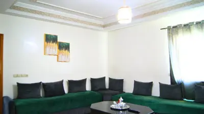 a living room with green couches and a table at City Center Stay - Résidence Omar 1 by ZenStay in Fès