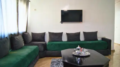 a living room with a couch and a tv at City Center Stay - Résidence Omar 1 by ZenStay in Fès