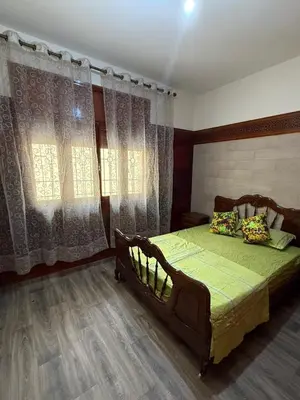 a bedroom with a bed with green sheets and curtains at Apartment in downtown Fez in Fès