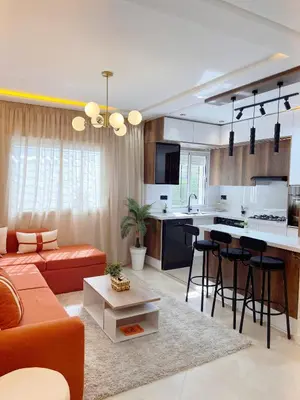 a living room with a orange couch and a kitchen at Dream apartment in Meknès