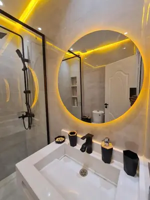 a bathroom with a sink and a round mirror at Dream apartment in Meknès