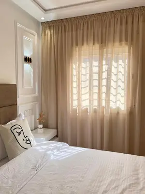 a bedroom with a white bed and a window at Dream apartment in Meknès