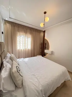 a bedroom with a large white bed and a window at Dream apartment in Meknès