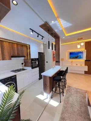 a kitchen with white cabinets and a island with bar stools at Dream apartment in Meknès