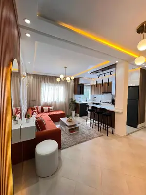a living room with a red couch and a kitchen at Dream apartment in Meknès