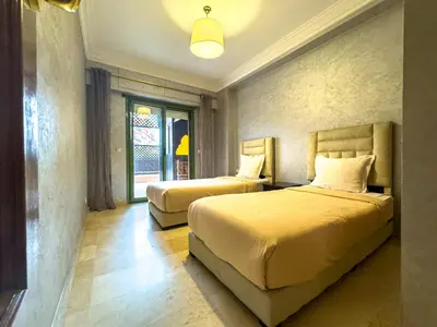 a bedroom with two beds and a window at Gueliz 2-BR Apt Majorelle Garden Spacious Terrace in Oulad Akkou