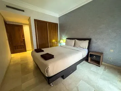 a bedroom with a large bed with a night stand at Gueliz 2-BR Apt Majorelle Garden Spacious Terrace in Oulad Akkou