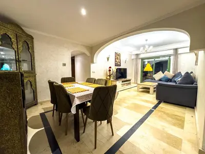 a dining room with a table and chairs and a couch at Gueliz 2-BR Apt Majorelle Garden Spacious Terrace in Oulad Akkou