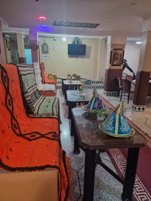 a living room with couches and tables in a room at Café restaurant in Issafene