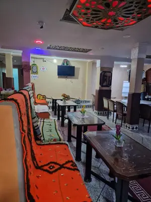 a room with tables and couches in a restaurant at Café restaurant in Issafene