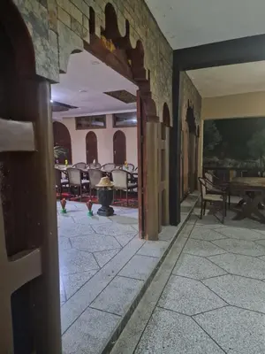 an empty hallway with tables and chairs in a building at Café restaurant in Issafene