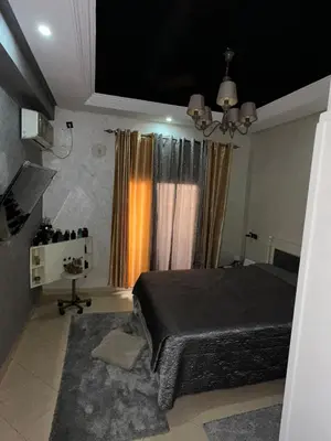 a bedroom with a bed and a table in it at Appart familial moderne de luxe Location journalière ou longue durée in Khemisset
