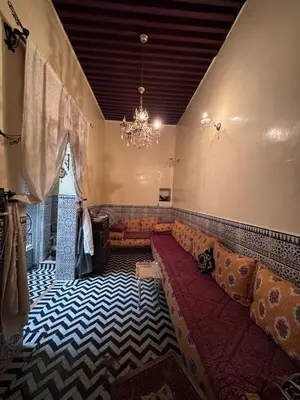 a living room with a couch and a chandelier at Hadi house in Fès