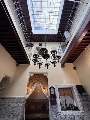 a chandelier hanging from the ceiling of a building at Hadi house in Fès