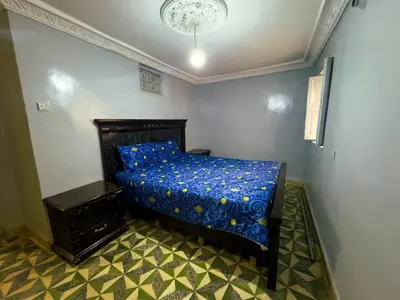 a bedroom with a bed with a blue comforter at vintage in Fès