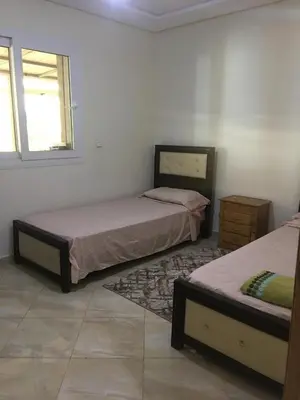 a bedroom with two beds and a window at appartement tanger in Oulad Akkou