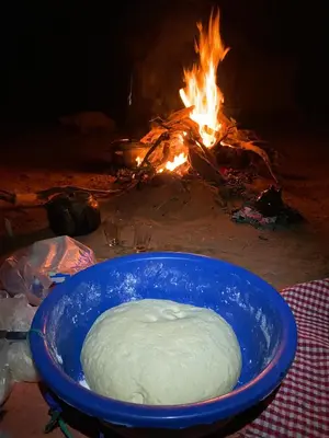 a bowl of dough in front of a fire at Desert Mhamid in Mhamid