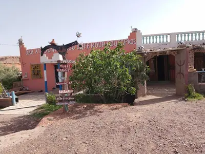 a sign in front of a building with a tree at امردول تسكوكت امرزكان ورزازات in Ouarzazate