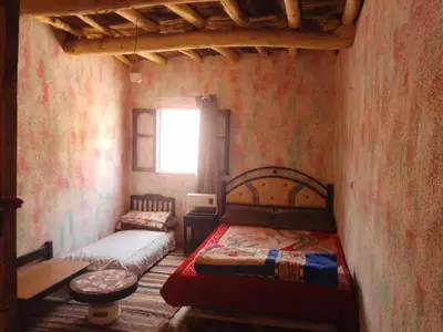 a small bedroom with a bed and a window at امردول تسكوكت امرزكان ورزازات in Ouarzazate