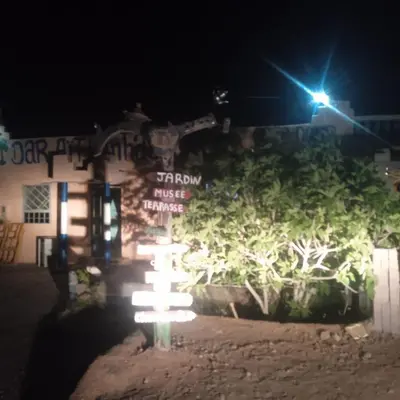 a sign in front of a building at night at امردول تسكوكت امرزكان ورزازات in Ouarzazate