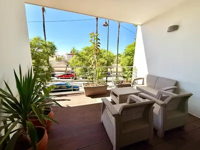 a balcony with chairs and plants and a large window at Luxueux appartement à Prestigia avec Wifi Fibre 100Mo in Fès