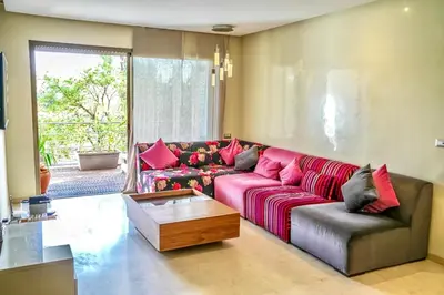 a living room with a red couch and a coffee table at Luxueux appartement à Prestigia avec Wifi Fibre 100Mo in Fès