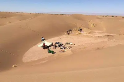 a group of people in a desert with a tent at Casa de las Estrellas in Mhamid