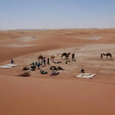 a group of people and horses in the desert at Casa de las Estrellas in Mhamid