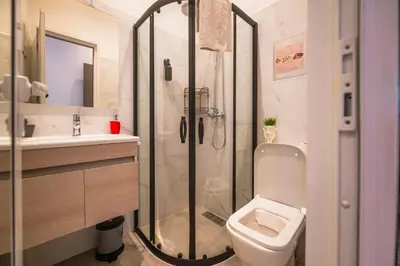 a bathroom with a shower and a toilet and a sink at Villa Roswell with Pool Privatisation in Heddad