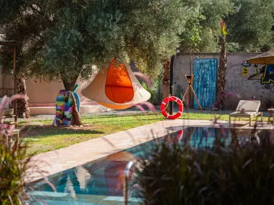 a swimming pool with a towel hanging from a tree at Villa Roswell with Pool Privatisation in Heddad