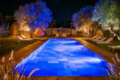 a swimming pool at night with trees and a tent at Villa Roswell with Pool Privatisation in Heddad