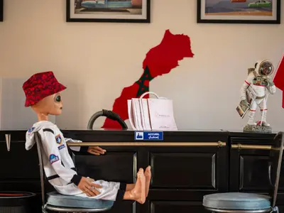 a doll sitting in a chair in front of a desk at Villa Roswell with Pool Privatisation in Heddad