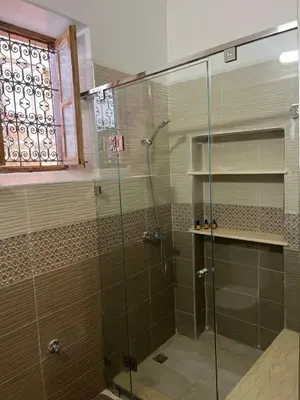 a shower with a glass door in a bathroom at Riad Dar Mama Laila in Fès