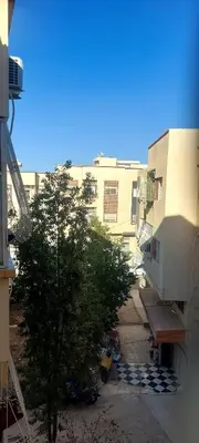 a view of a building with a tree in front of it at El Borj apartment in fes-Fes in Fès