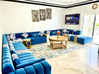a living room with blue couches and a table at Fabuleux appartement au Centre Ville avec Wifi 100 Mo in Fès