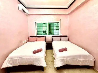two beds in a small room with a window at Fabuleux appartement au Centre Ville avec Wifi 100 Mo in Fès