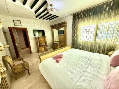 a bedroom with a bed and a chair and a window at Fabuleux appartement au Centre Ville avec Wifi 100 Mo in Fès
