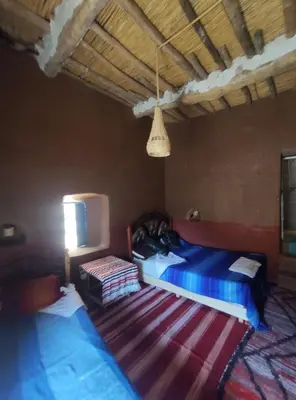 a bedroom with two beds and a rug at Casa Rural Todra Gorges in Tinerhir