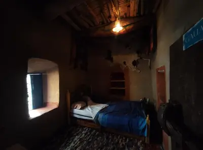 a bedroom with a bed with a person laying on it at Casa Rural Todra Gorges in Tinerhir