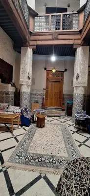 a large room with a rug and a wooden door at dar ben issa in Fès