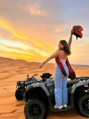 a woman standing on a wheeler in the desert at Melody Desert Camp Merzouga in Merzouga