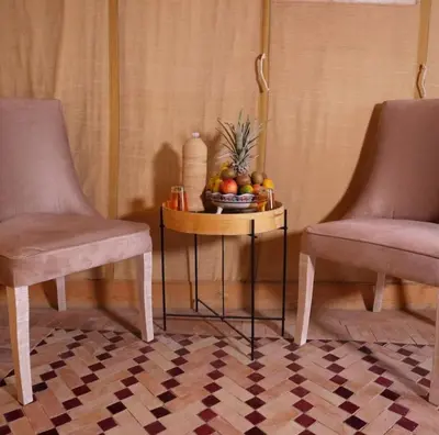 two chairs and a table with a bowl of fruit at Melody Desert Camp Merzouga in Merzouga