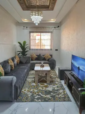 a living room with a couch and a tv at Meknes centre ville Appartement neuf moderne et bien équipé in Meknès