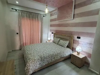a bedroom with a bed and a striped wall at Meknes centre ville Appartement neuf moderne et bien équipé in Meknès